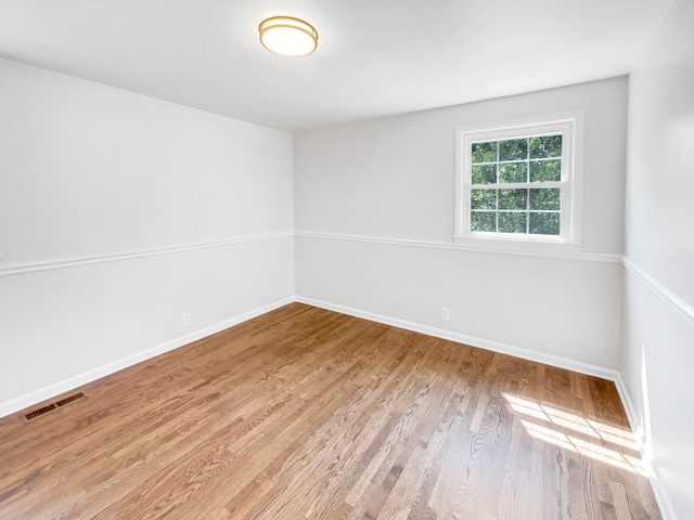 unfurnished room with hardwood / wood-style flooring