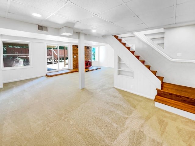 basement featuring a paneled ceiling and carpet flooring