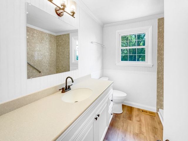 bathroom with crown molding, hardwood / wood-style floors, walk in shower, toilet, and vanity