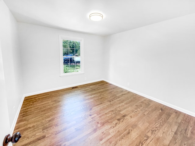 unfurnished room with wood-type flooring