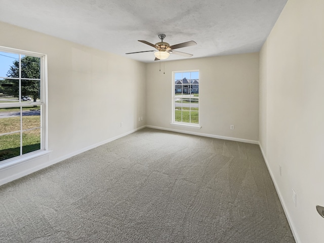 carpeted empty room featuring ceiling fan and a textured ceiling