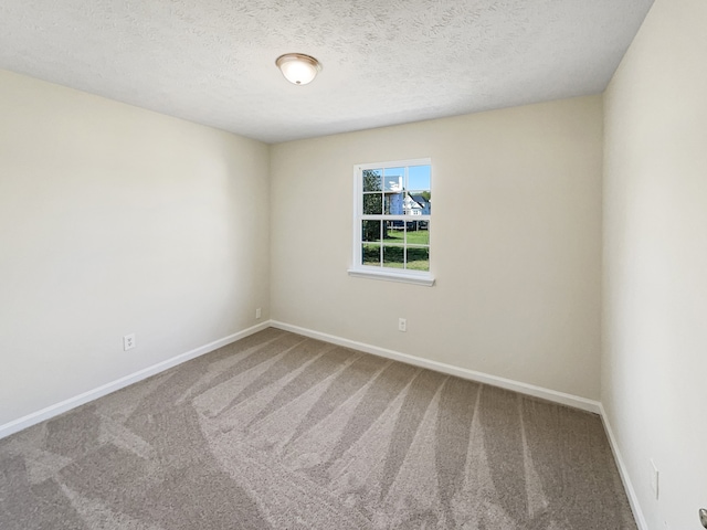 carpeted spare room featuring a textured ceiling