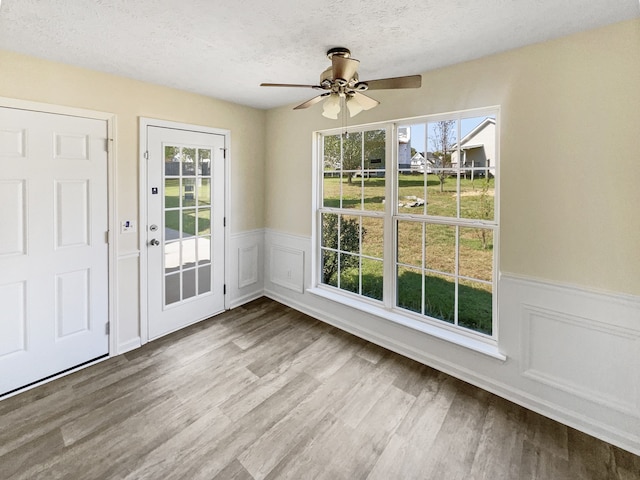 interior space with hardwood / wood-style floors, ceiling fan, and a textured ceiling