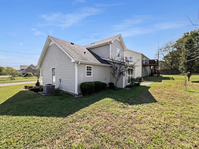 view of property exterior with a yard and central AC unit