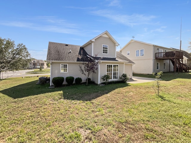 rear view of house with cooling unit, a lawn, and a wooden deck