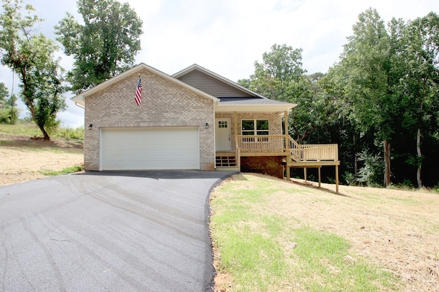 view of front facade with a front yard, a garage, and a porch