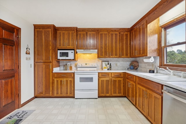 kitchen featuring backsplash, sink, and white appliances