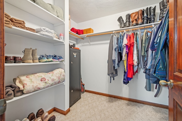 walk in closet featuring light colored carpet