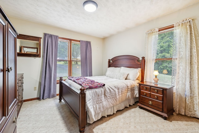 bedroom featuring light carpet and a textured ceiling