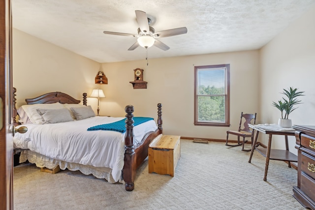 carpeted bedroom with ceiling fan and a textured ceiling