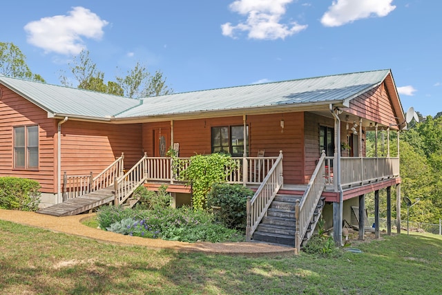 rear view of property featuring a deck and a yard