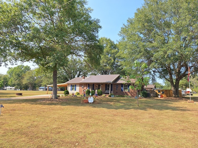 ranch-style house featuring a front yard and fence