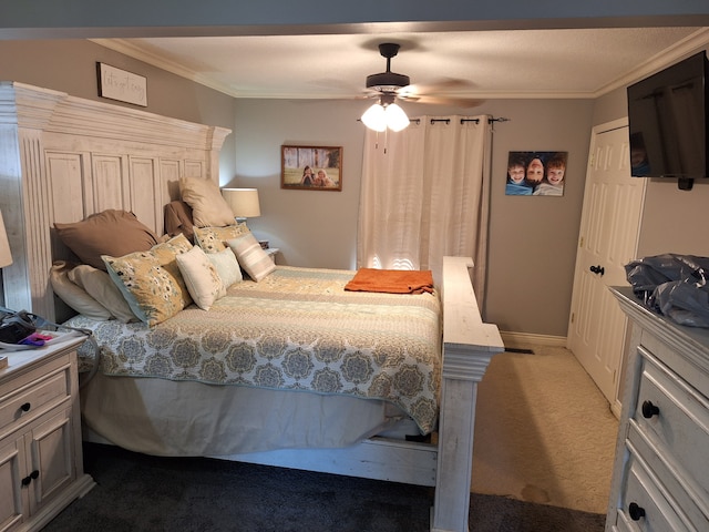 carpeted bedroom featuring ornamental molding, ceiling fan, and a closet