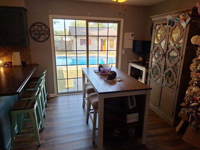 dining area featuring dark wood-type flooring and a healthy amount of sunlight