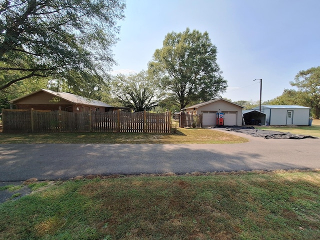 view of yard with an outbuilding, a garage, and a fenced front yard