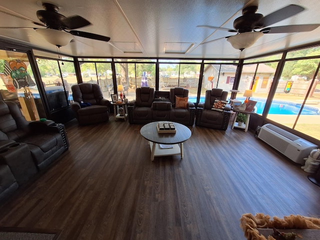 sunroom / solarium with a wall mounted air conditioner and ceiling fan