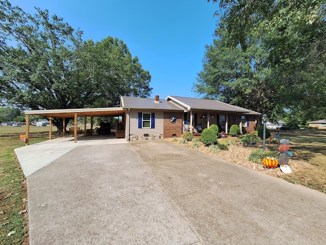 ranch-style house with an attached carport, covered porch, a chimney, concrete driveway, and crawl space