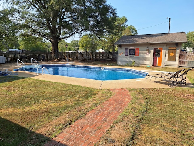 view of swimming pool featuring an outbuilding, a yard, a fenced backyard, and a fenced in pool