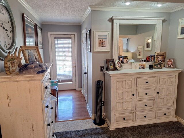 bedroom featuring wood-type flooring, crown molding, and a textured ceiling