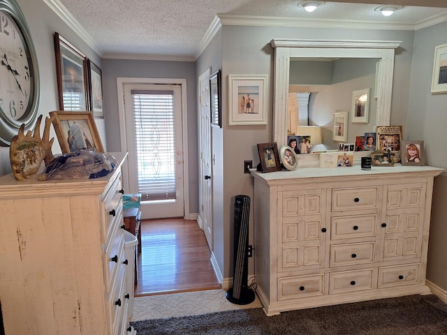 bathroom with vanity, wood finished floors, baseboards, a textured ceiling, and crown molding