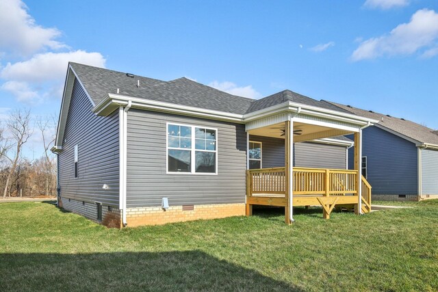 back of house with ceiling fan, a deck, and a yard