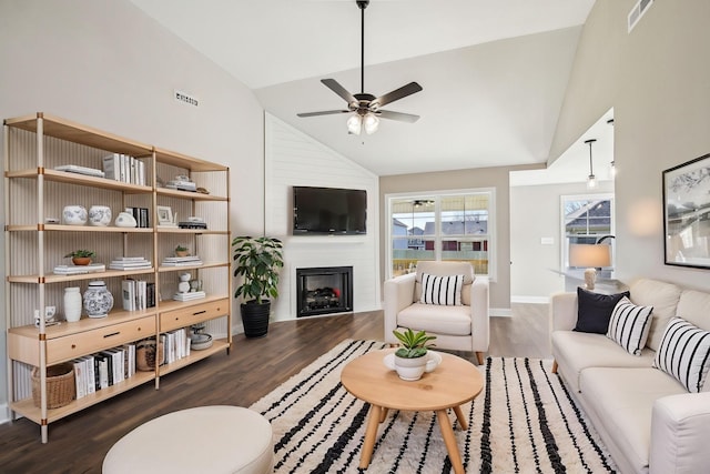 living room featuring lofted ceiling, a large fireplace, and dark hardwood / wood-style flooring