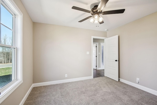 unfurnished room with ceiling fan and carpet