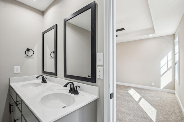 bathroom with a tray ceiling and vanity