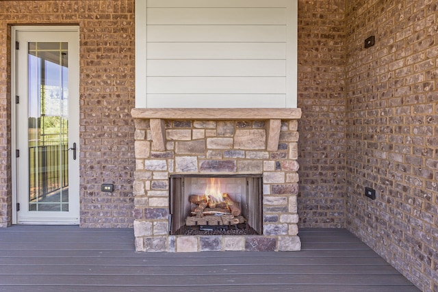 wooden deck with an outdoor stone fireplace