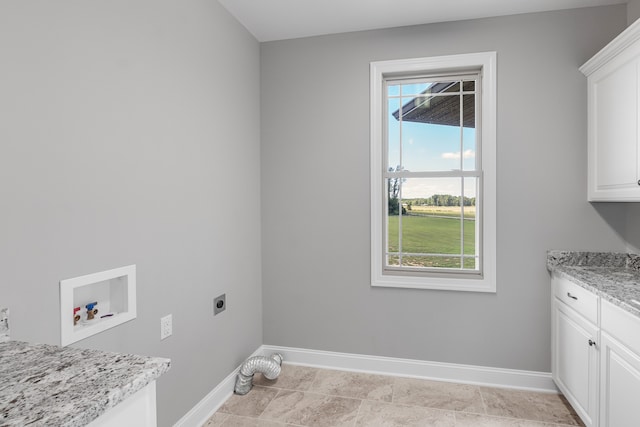 laundry area with hookup for an electric dryer, hookup for a washing machine, and cabinets