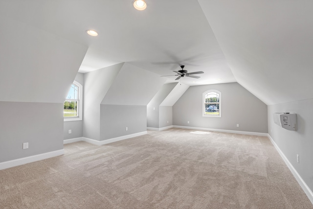 bonus room with light carpet, lofted ceiling, plenty of natural light, and ceiling fan