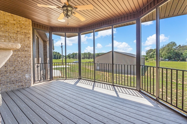 unfurnished sunroom featuring ceiling fan and wood ceiling