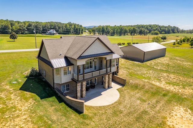 back of property featuring a yard and a rural view