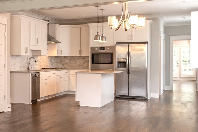 kitchen featuring appliances with stainless steel finishes, a notable chandelier, dark hardwood / wood-style floors, pendant lighting, and a kitchen island