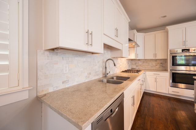 kitchen with tasteful backsplash, dark wood-type flooring, stainless steel appliances, sink, and white cabinets