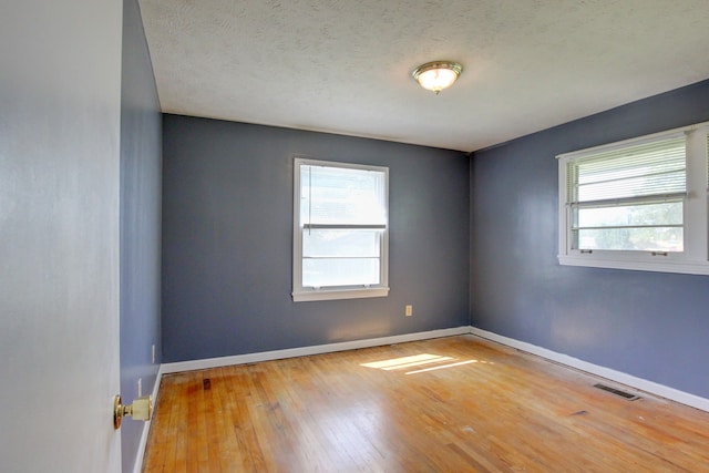 empty room featuring a textured ceiling and hardwood / wood-style floors