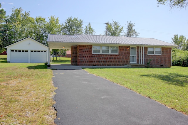 ranch-style home featuring a front lawn, a carport, an outdoor structure, and a garage