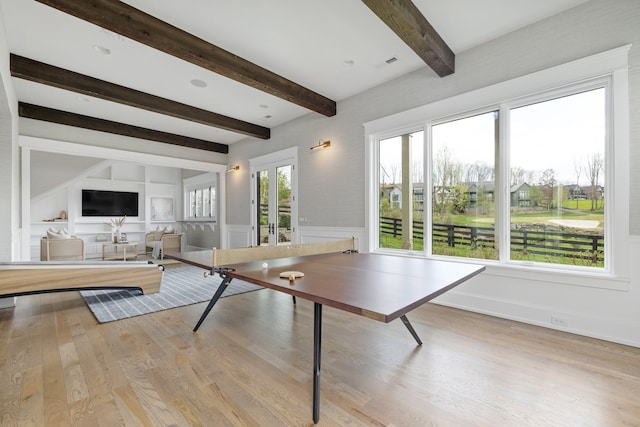 game room featuring light wood-type flooring, beamed ceiling, and a healthy amount of sunlight