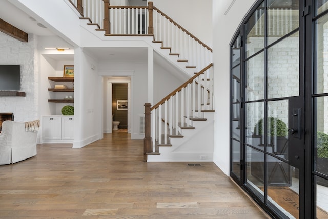 entrance foyer with a fireplace and light hardwood / wood-style flooring