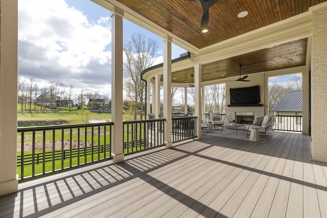 wooden deck featuring a lawn and ceiling fan