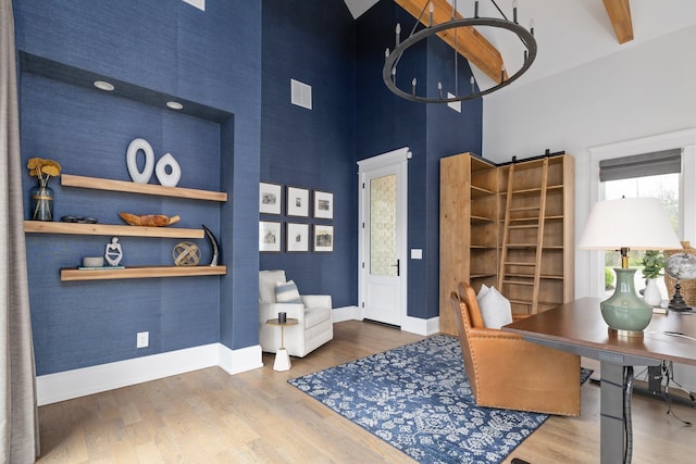 office featuring a high ceiling, hardwood / wood-style floors, and beam ceiling