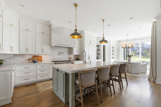 kitchen featuring dark hardwood / wood-style flooring, white cabinetry, and a kitchen island with sink