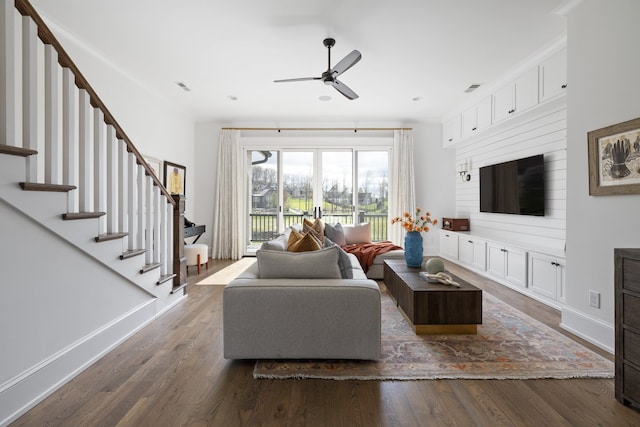 living room featuring dark wood-type flooring and ceiling fan