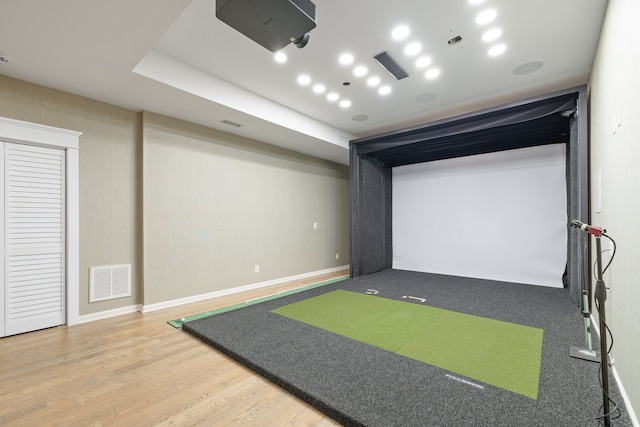 rec room with wood-type flooring and golf simulator