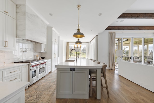 kitchen featuring white cabinetry, double oven range, and light hardwood / wood-style flooring