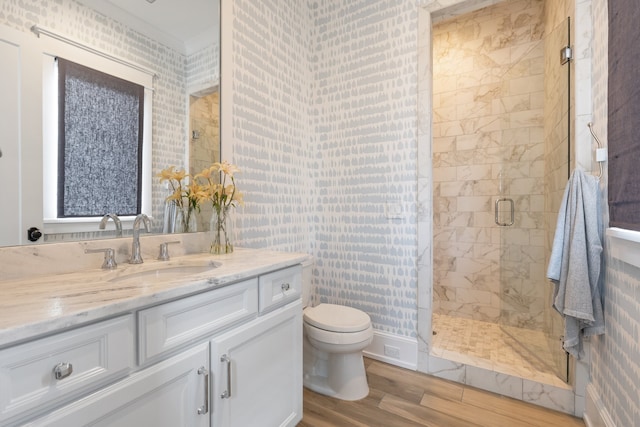 bathroom featuring vanity, toilet, wood-type flooring, and a shower with door