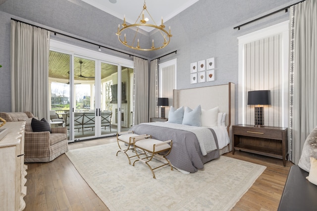 bedroom with access to exterior, hardwood / wood-style floors, and a chandelier