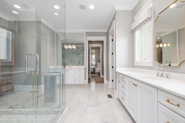 bathroom with crown molding, vanity, and plenty of natural light