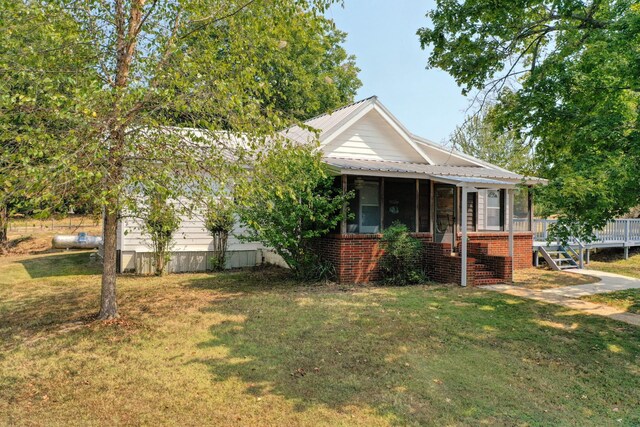 view of front of home featuring a front lawn and a sunroom