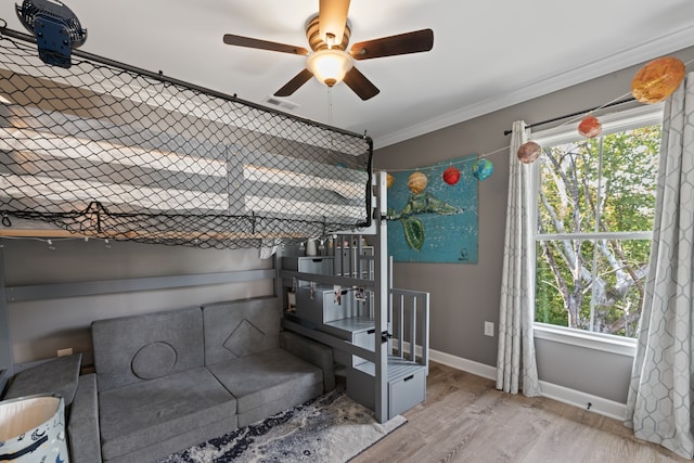 bedroom featuring crown molding, ceiling fan, light wood-type flooring, and multiple windows